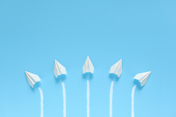 それぞれの進路に分かれて進む紙飛行機 1 5機