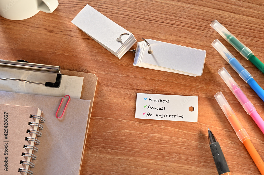 Poster there is a a word card with business process re-engineering written on it. they are on the desk alon