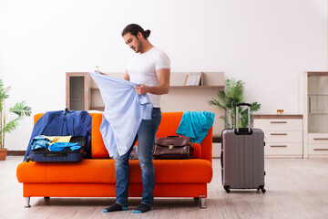 Young man student preparing for trip at home