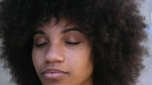 portrait and close up of beautiful young African or American woman with close eyes dreaming or thinking 

