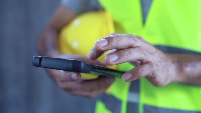 Close up construction worker touch screen on smart phone