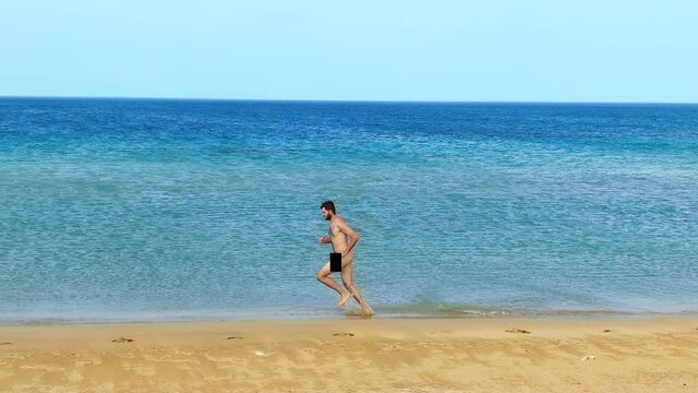 Naked man jogging nudist beach. Nudes people naturalist running ocean shore. Nakedness person enjoy summer beach vacation. Male body nudism. Jogger human near sea. Runner nudity man resort naturalism.