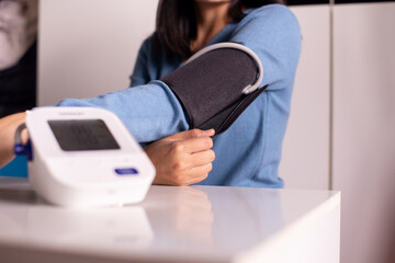 Patient woman using blood pressure & heart rate monitors in yourself at home