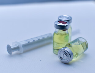 Vial of drugs injection or vaccine with syringe needle on a white background for cure and...