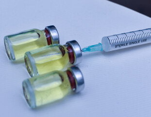 Vial of drugs injection or vaccine with syringe needle on a white background for cure and prevention of sickness 