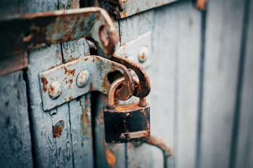 A rusty old lock on a wooden door.