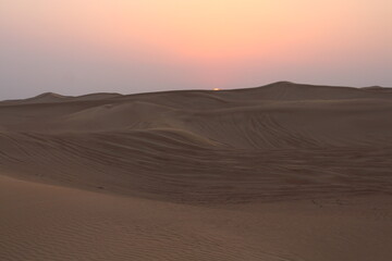 Obraz na płótnie Canvas Little girl looking at the Sunset at Dubai's Desert by Christian Gintner