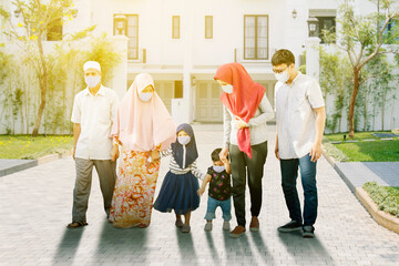Muslim family in face mask walks together on road