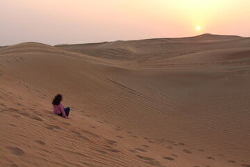 Fototapeta na wymiar Little girl looking at the Sunset at Dubai's Desert by Christian Gintner