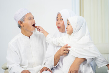 Muslim little girl feeding cookies her grandparents