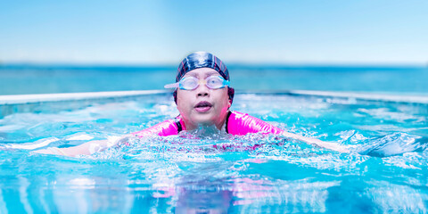 Senior woman swimming breaststroke on pool