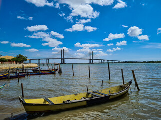 Fototapeta premium Barcos de pesca a remo e uma ponte longa ao fundo