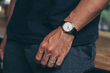 fashionable wearing stylish looking at luxury watch on hand check the time at workplace.concept for...