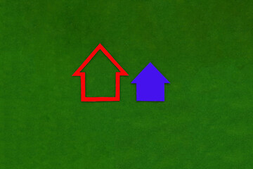 Two houses of blue and red color on a green background. Shares in the property of residential premises. Sale of real estate.