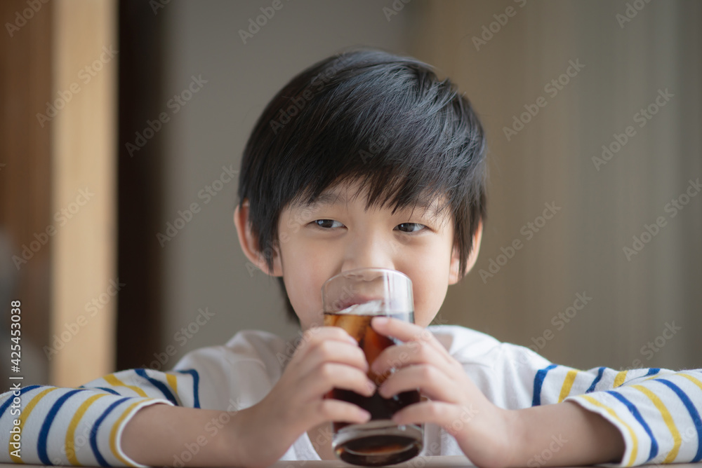 Wall mural Little asian boy drinking soft drink coca cola soda