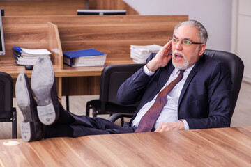 Old businessman employee sitting in the office