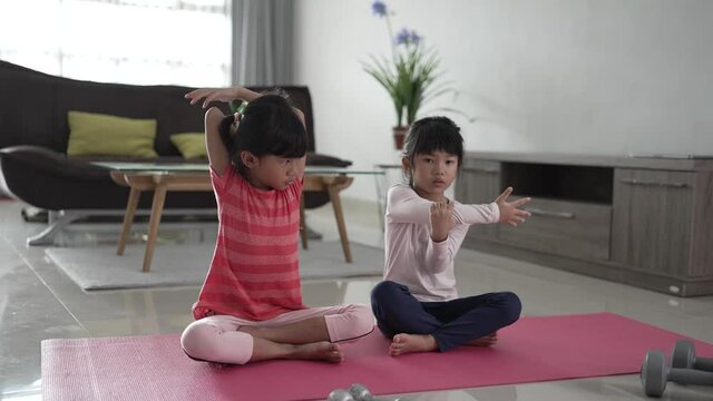 portrait of asian happy two little girl exercising at home