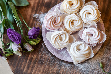 Fototapeta na wymiar confectioner sprinkles icing sugar with dessert. Powder sugar falls on fresh perfect cupcakes or meringues