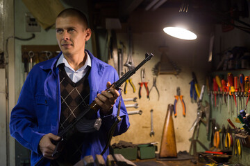 Gunsmith checks Kalashnikov assault rifle in a weapons workshop