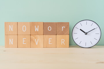 今しかない｜「NOW or NEVER」と書かれた積み木ブロックと時計