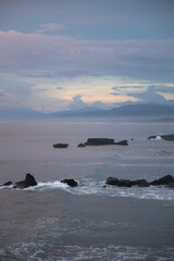 Incredibly beautiful sunset by the ocean in Bali. The bright sun sets in the water. The rays of the...