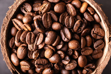black coffee beans arabica, aromatic in a coconut bowl, close-up