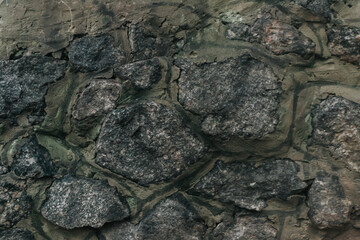 The texture of a stone medieval castle wall with natural defects. Scratches, cracks, crevices, chips, dust, roughness, abrasion. Template for design and background.Copy space