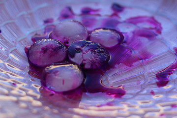 abstract image consisting of a purple background and pieces of ice with dark spots