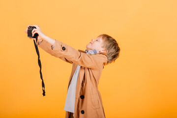 Child boy red head photographer with retro photocamera in studio