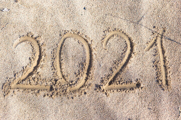 2021 inscription on the sand of the beach. Summer beach holidays in 2021. The message is handwritten