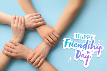 Women holding hands together on color background. Friendship Day celebration