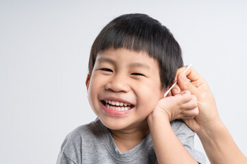 Asian mother cleaning her 4 years old boy ear with cotton swab