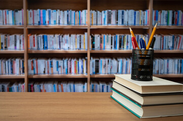 Blurred bookshelves and books on the desk. Education concept.