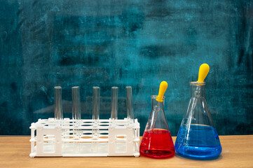 Scientific experiment tools on the desk. Empty blackboard. Education concept.