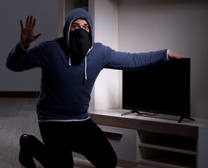 Burglar thief stealing tv from apartment house