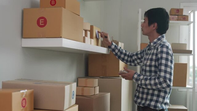 online business owner write down delivery details and tag on the box for delivery. The seller puts a sign on the product that the customer has reserved. Online trading and management concept.