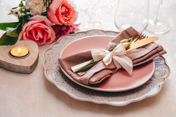  Wedding table setting concept. Plate, cutlery on linen napkin and flowers, close up, toned photo soft focus