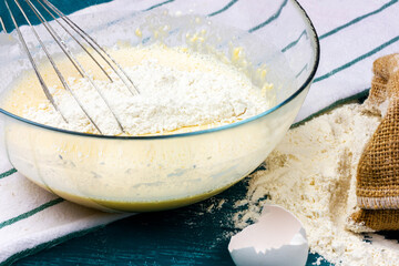 Glass bowl with a whisk. The process of making waffle dough.