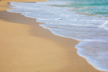Rolling a wave with foam on a sandy shore