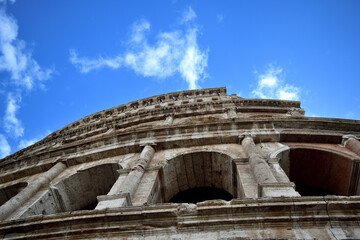 exterior of Colosseum on blue sky with white clouds background - Rome, Italy, Europe