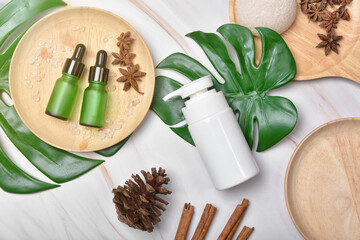 Fototapeta na wymiar Cosmetic bottle containers packaging with green herbal leaves, Blank label for organic branding mock-up, Natural skincare beauty product concept.