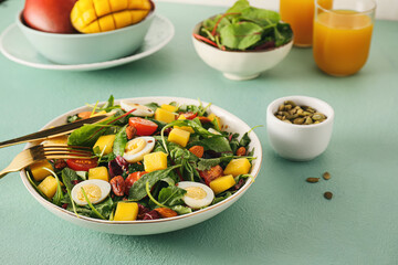 Plate of fresh mango salad on color background