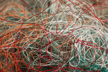 Multi-colored tangled threads abstract texture pattern background. Macro shot of colorful needlecraft silk thread ropes.