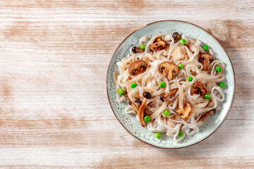 Konjac pasta with mushrooms and green peas, shot from the top