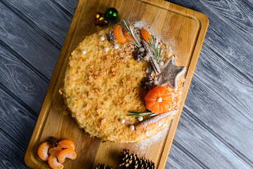 Traditional napoleon cake decorated with tangerines and christmas cookies. Christmas or New Year...