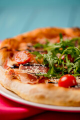 Pizza close-up over blue rustic wooden background.
