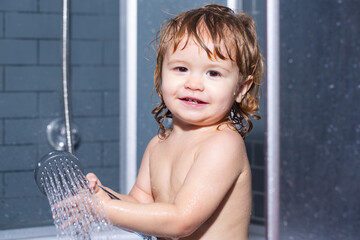 Wash infant hygiene and health care. Funny baby kid bathed in foam and washing in bathtub at home.