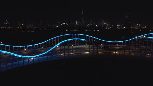Black SUV car drive on Meydan VIP bridge in Dubai, UAE at night, aerial panorama