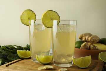 Glasses of ginger beer and ingredients on cutting board
