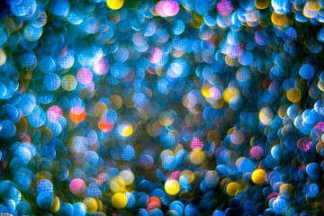 A blurry photo of a bunch of balls in the air. The background is a mix of blue, yellow, and pink colors, creating an abstract and colorful effect